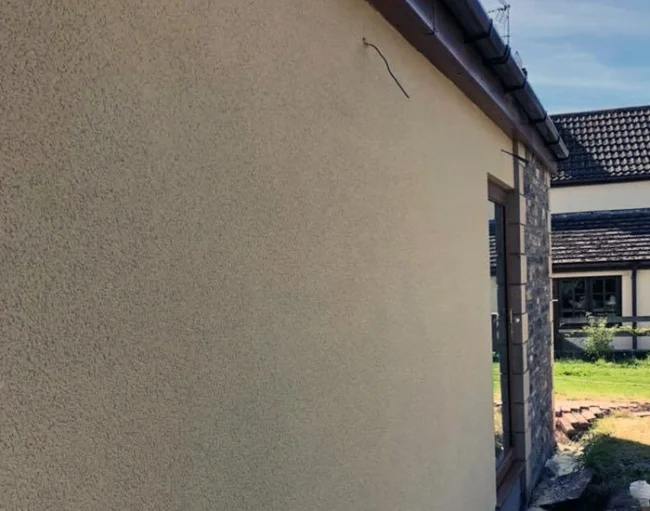 Smooth cream-coloured exterior wall with a fine render finish on a modern house, highlighting the even texture and craftsmanship typical of a high-quality rendering service in the South West.